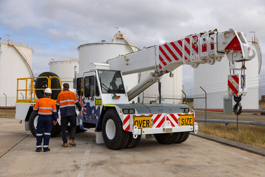 Workers walking towards the side of the cherry picker truck.