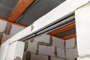 A white wall with a wooden beam and a metal bar