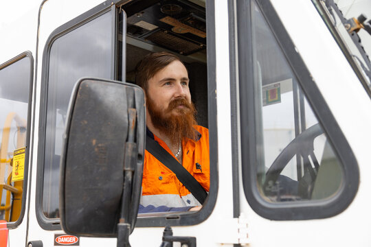 Young adult worker on the trucks driver seat.