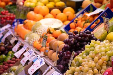 fresh fruits displayed on public market shelf with close-up grapes, orange, lemon, strawberry