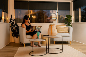 Woman reading book in cosy, dimly lit living room with serene evening ambiance