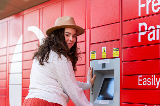 Young lady picking up parcel from post office collection boxes