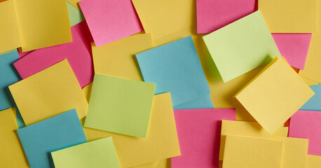 Selective focus of colorful sticky notes and paper clips. Flat lay, top view. Copy space