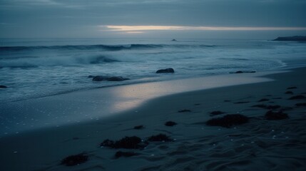 A serene beach scene at dusk, featuring gentle waves lapping at the shore under a moody sky.