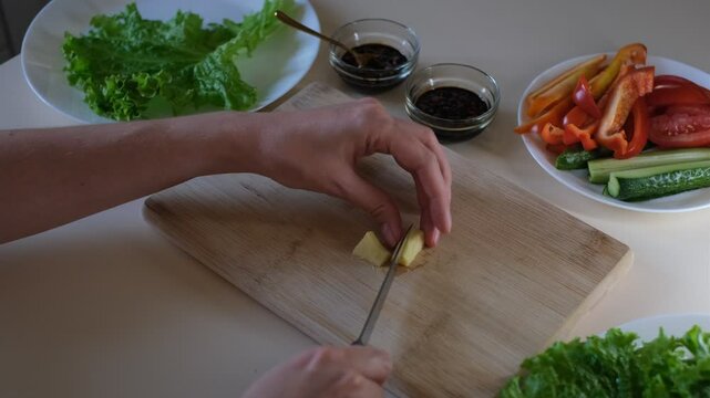 woman housewife chopping ginger on a wooden board