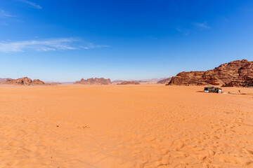 Fototapeta premium Scenic view of Wadi Rum Desert in Jordan. Landscape with Rocky Formation Under Blue Sky and Wispy Clouds..