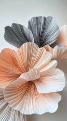Gigantic pleated flowers made of paper, in a peach and grey color palette, against a white background