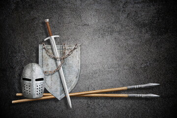 knight sword shield helmet and lance on abstract black background