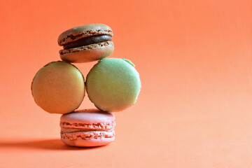 Macaroons stacked, isolated, on orange background and copy space.	