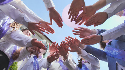 Students forming a circle, uniting in celebration of their graduation and last day of school in...