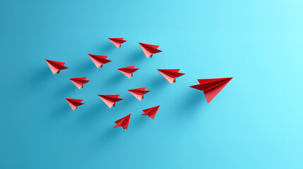 Red paper planes flying in formation on blue background, symbolizing leadership