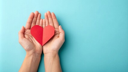 Fototapeta premium Woman holding red paper heart in open palms on turquoise background