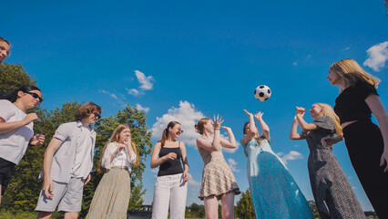 Teenage high school students having fun playing soccer outside on a sunny summer day