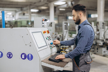Factory worker operating industrial machinery producing PVC windows and doors