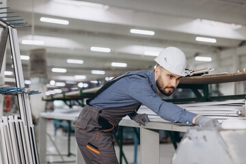 Factory worker checking aluminum and PVC window and door frames