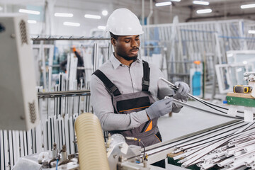 Factory worker assembling aluminum window frames in production line