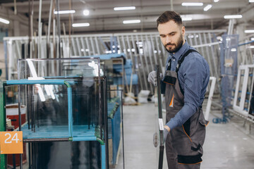 Fototapeta premium Factory worker carrying glass for pvc windows and doors production