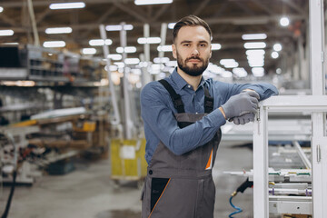 Factory worker posing leaning on a window frame
