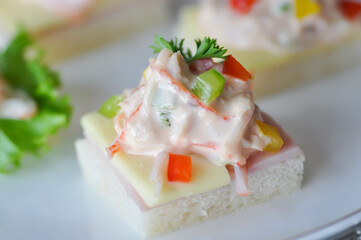 canape or toast with ham , cheese , crab stick and tuna