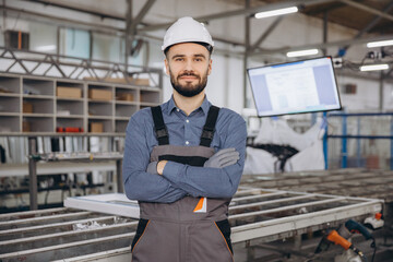 Factory worker posing with crossed arms in windows and doors production line
