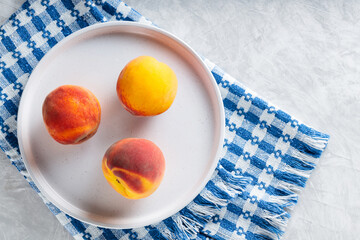 Ripe Peaches on White Plate with Linen Blue White Napkin