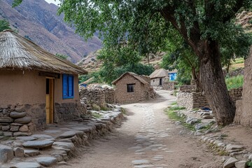 Mountain village pathway with traditional mud houses and stone walls.