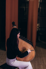 A girl plays the bandura while giving a concert