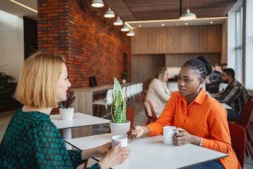 Two Women Sitting at a Table Talking