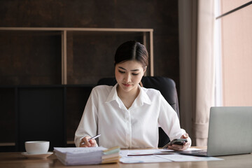 Asian businesswoman focused while working at office desk, Concept of productivity