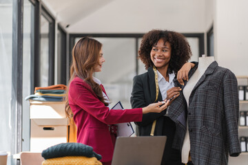 Two Female Designers Collaborating on Shirt Designs in a Modern Studio Setting with Professional Tools and Materials