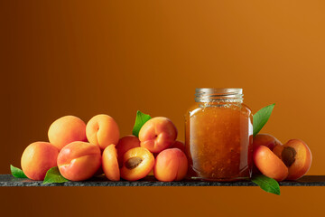 Apricot jam in glass jar and fresh fruits.