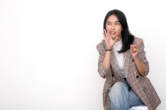 Asian young woman whispering some gossips to her friend