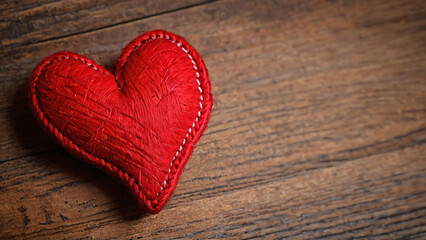 Fototapeta premium knitted red heart on a brown surface
