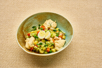 A bowl of food with a creamy sauce and vegetables