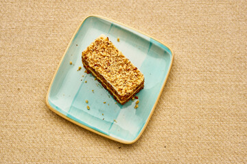 A piece of cake with nuts on top of a blue plate