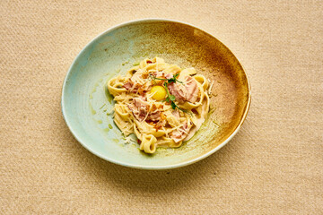 A plate of pasta with meat and cheese on top