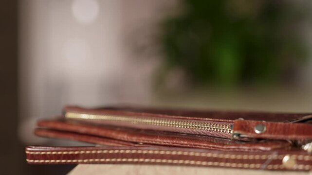 Woman putting wallet on table, close-up. Female hand puts purse while coming in room