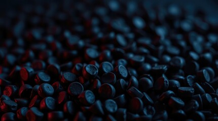Fototapeta premium Dark chocolate pieces are spread out over a shadowy surface, glimmering softly under dim light, highlighting their rich color and texture