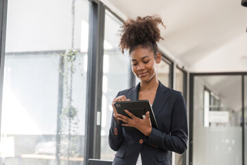 Confident Businesswoman Analyzing Work Plan on Digital Tablet in Modern Office Setting