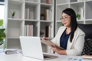 Middle-aged Female Accountant Working on Financial Documents in Modern Office Setting