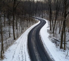 empty road in winter forest seen from above