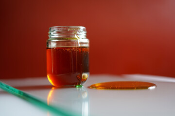 Glass Jug of Pure Bee Honey on glass Table. Stock Photo. closeup