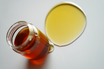 Bee Honey in a Glass Jug with an Open Lid and Spreading Honey. High-Resolution Stock Image for Commercial Use