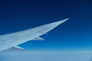 Airplane wing in the blue sky.