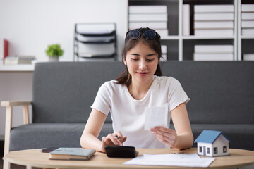 Young Woman Planning Finances for Buying a House, Calculating Expenses and Budgeting with Documents...