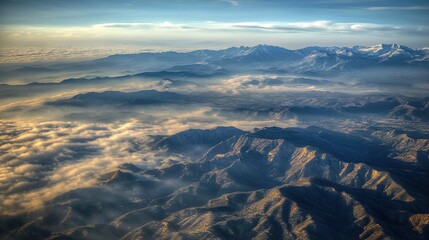 Naklejka premium Aerial Enigma: Mysterious Mountains Veiled in Low Clouds with Dramatic Lighting