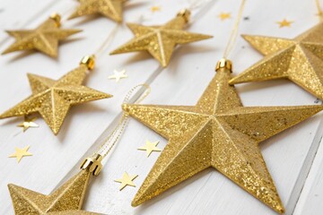 Obraz premium Sparkling gold Christmas stars on white backdrop