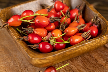 red rosehip fruits on a black tea table