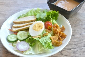 fresh vegetable topping boiled egg topping crispy fried taro dressing Indian sauce salad on plate 