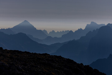 Aerial view of the mountain silhouettes on the horizon. Misty and foggy sky with Dolomites mountain range on the horizon. Blue mist in the mountains
